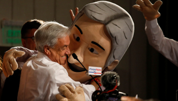 Former President Sebastian Pinera hugs a man wearing a Pinera mask after the November 19 election (Reuters/Carlos Garcia Rawlins)