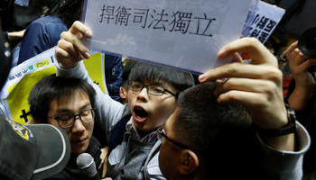 Student leader Joshua Wong holds up a sign reading "defend judicial independence" (Reuters/Bobby Yip)