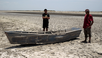 Residents stand next to their boat on the dried ground at the Tisma lagoon wetland park due to drought affecting Tisma town, Nicaragua April 20, 2016 (Reuters/Oswaldo Rivas)