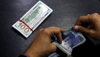 A currency trader in Islamabad counting Pakistani rupees and US dollars (Reuters/Caren Firouz)