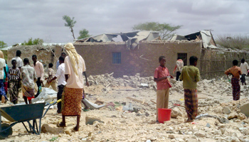 People walk through rubble after a US airstrike, reported to have killed an al-Shabaab leader (Reuters/Abdi Guled)