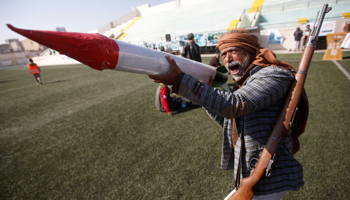 A tribesman loyal to the Houthi movement carries a cardboard model of a missile during a gathering to mark 1000 days of the Saudi-led military intervention in the Yemeni conflict, in Sanaa, Yemen December 21, 2017 (Reuters/Mohamed al-Sayaghi)