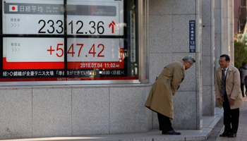 Men exchange greetings outside a brokerage in Tokyo (Reuters/Kim Kyung-Hoon)