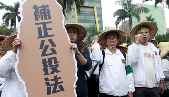 Protesters carry a placard saying "Mend referendum law" in Taipei in 2015 (Reuters/Pichi Chuang)