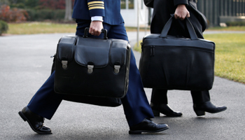 A military aide carries the 'nuclear football', which contains launch codes for the US nuclear arsenal and which travels with the sitting US president (Reuters/Jonathan Ernst)