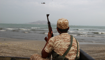 A Yemeni soldier looks as a UAE military helicopter hover over the sea during the search for the wreckage of a crashed UAE military helicopter, Aden, Yemen, 2016 (Reuters/Fawaz Salman)