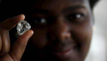 A visitor holds a diamond during a De Beers diamond sale in Botswana (Reuters/Siphiwe Sibeko)