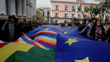 People march with a giant flag proclaiming support for Bolivia's territorial claim. (Reuters/David Mercado)
