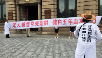 Investors who lost money protest outside a bank in Shanghai (Reuters/Engen Tham)