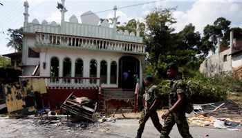 Sri Lankan Special Task Force troops walking past a damaged mosque in Kandy (Reuters/Dinuka Liyanawatte)