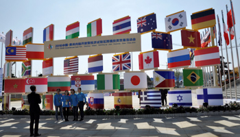 People stand near signboards of a cross-border investment and trade fair in Guiyang, Guizhou Province, China (Reuters/Shu Zhang)