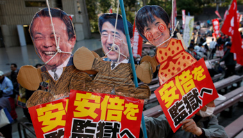 Protesters hold placards during a rally denouncing Japanese Prime Minister Shinzo Abe, his wife Akie, and Finance Minister Taro Aso over a suspected cover-up of a cronyism scandal in Tokyo, March 25, 2018 (Reuters/Issei Kato)