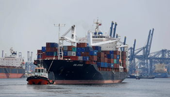 A tug boat guiding a ship away from the Tanjung Priok port (Reuters/Darren Whiteside)