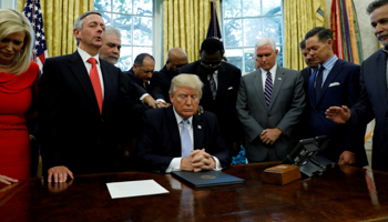 Faith leaders place their hands on the shoulders of US President Donald Trump as he takes part in a prayer for those affected by Hurricane Harvey, September 2017 (Reuters/Kevin Lamarque)