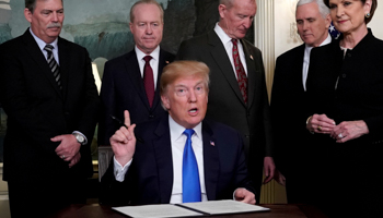 US President Donald Trump, surrounded by business leaders and administration officials, prepares to sign a memorandum on intellectual property tariffs on Chinese high-tech goods, March 22, 2018 (Reuters/Jonathan Ernst)