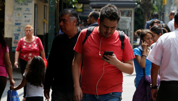 A man looks at his mobile phones in Mexico City, Mexico (Reuters/Carlos Jasso)