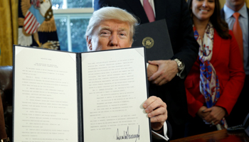 President Donald Trump holds up an executive order rolling back regulations from the 2010 Dodd-Frank law on Wall Street reform, February 2017 (Reuters/Kevin Lamarque)