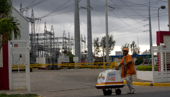 A man pushes an ice-cream cart past an electrical substation in Santo Domingo (Reuters/Eduardo Munoz)