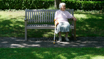 A pensioner sits on a bench next to a residential home for the elderly in Planegg near Munich (Reuters/Michaela Rehle)