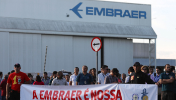 Employees with a sign reading “Embraer is ours. No sale to Boeing.” (Reuters/Roosevelt Cassio)