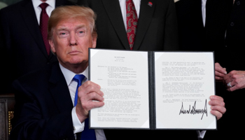 US President Donald Trump holds his memorandum on intellectual property tariffs on high-tech goods from China, at the White House in Washington, US, 2018 (Reuters/Jonathan Ernst)