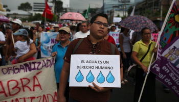 A man participates in a protest against privatisation of water in San Salvador, El Salvador June 16, 2018. The sign reads "Water Is a Human Right" (Reuters/Jose Cabezas)