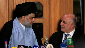 Iraqi Shia cleric Moqtada al-Sadr, whose bloc came first, looks at Iraqi Prime Minister Haider al-Abadi during a news conference in Najaf, Iraq June 23, 2018 (Reuters/Alaa al-Marjani)