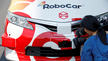 A camerawoman films a laser scanner on ZMP Inc's self-driving RoboCar MiniVan in Tokyo (Reuters/Toru Hanai)