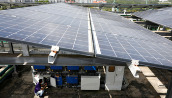 An Electrify SG engineer installs a PowerPod to record data of photovoltaic solar panels, Singapore (Reuters/Edgar Su)