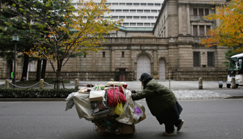 A man pushes a cart with his belongings outside the Bank of Japan headquarters in Tokyo (Reuters/Yuriko Nakao)