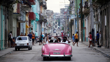 Tourists ride a vintage car in Havana, Cuba, June 11, 2018 (Reuters/Alexandre Meneghini)