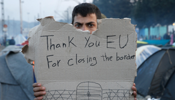 A refguee holds a message, "Thank you EU for closing the border", during a protest at the Greek-Macedonian border (Reuters/Alkis Konstantinidis)