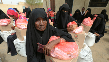 Women sit next to food aid delivered by the International Committee of the Red Cross to internally displaced people in the Red Sea port city of Hodeidah, Yemen, July 21, 2018 (Reuters/Abduljabbar Zeyad)