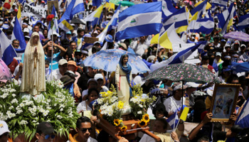 Demonstrators hold national flags during a march in support of the Catholic Church in Managua, Nicaragua July 28, 2018 (Reuters/Jorge Cabrera)