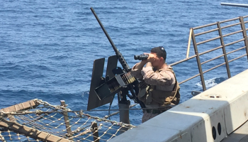 A gunner scans the sea aboard the USS New Orleans as it travels through the Strait of Hormuz (Reuters/Phil Stewart)