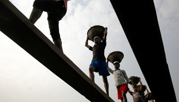 Bangladeshi workers unloading coal from a ferry (Reuters/Mohammad Ponir Hossain)