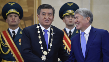 President Sooronbay Jeenbekov (L) shakes hands with his predecessor Almazbek Atambayev during his inauguration ceremony in November 2017 (Reuters/Vyacheslav Oseledko)