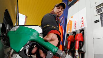 A worker pumps petrol into a car at a gas station in Quito (Reuters/Guillermo Granja)
