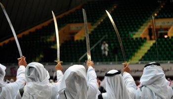 Members of a traditional dance team hold up their swords as they perform a Saudi dance known as "Arda" during the Janadriya culture festival at Der'iya in Riyadh (Reuters/Fayez Nureldine)