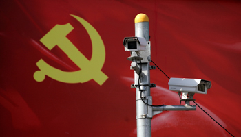 Security cameras attached to a pole in front of a flag of Communist Party of China (Reuters/Aly Song)