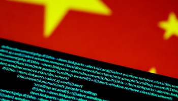 Computer code on a screen above a Chinese flag (Reuters/Thomas White)