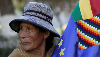 A woman holds a Bolivian maritime flag as she awaits the International Court of Justice (ICJ) verdict on Bolivia's ocean access, La Paz, October 1 (Reuters/David Mercado)
