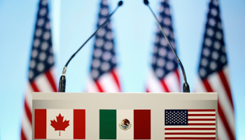 The US, Canadian and Mexican flags, seen on a lectern at the seventh round of NAFTA talks in Mexico City, March 5 (Reuters/Edgard Garrido)