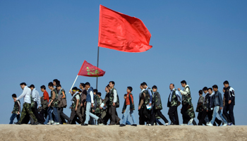 Militia members and a group of schoolboys attend a war memorial site in Iran’s Khuzestan province (Reuters/Morteza Nikoubazl)