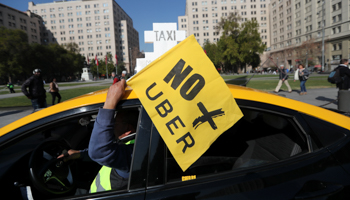 A taxi driver holds a flag reading "No more Uber" during a nationwide strike to protest against Uber Technologies in Santiago, Chile July 30, 2018 (Reuters/Ivan Alvarado)