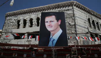 A poster of President Bashar al-Assad hangs from a ruined building, September 2018 (Reuters/Marko Djurica)