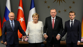 The German, Russian, Turkish and French leaders hold hands at a news conference after the Istanbul Syria summit, October 27 (Reuters/Emrah Yorulmaz)