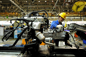 An employee works on an assembly line producing automobiles at a factory in Qingdao, Shandong Province, China (Reuters/Stringer)
