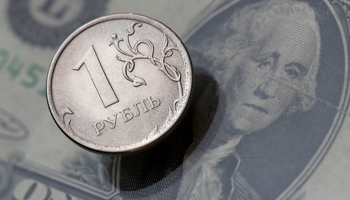 A Russian ruble coin on top of a US dollar bill (Reuters/Maxim Shemetov)