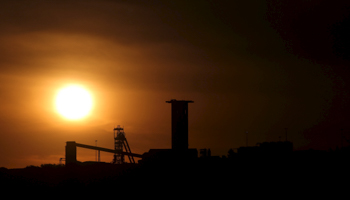 The sun sets behind a shaft outside the mining town of Carletonville, west of Johannesburg (Reuters/Siphiwe Sibeko)